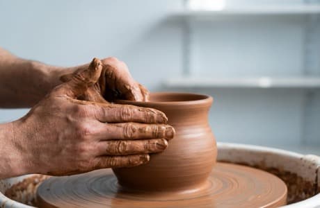 Artisan shaping clay on a pottery wheel